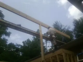 Carpenter setting a ridge beam over a new addition frame — Ice Dam Removal by Roofing Brothers in Carlstadt