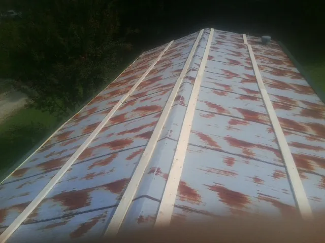 Rusted metal roof panels with new wood purlins before replacement — Storm Damage Roof Repair in Carlstadt by Roofing Brothers