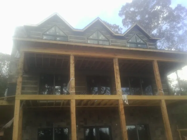 Dormers and porch framing on a large log home under construction — Roof Coating work by our crew in Carlstadt