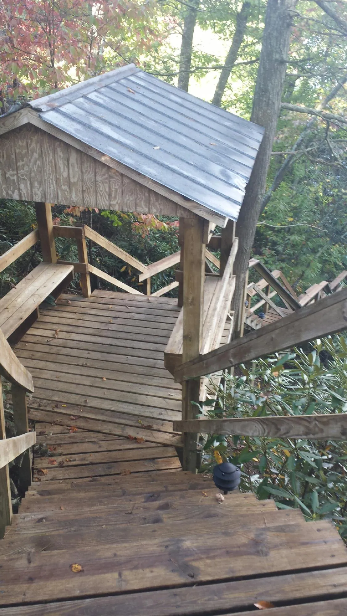 Metal roofed shelter over wooden steps on a wooded walkway — Skylight Repair & Installation work by our crew in Carlstadt